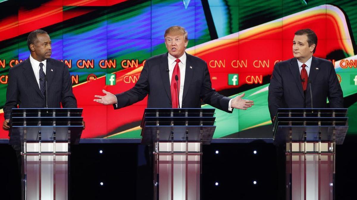 Ben Carson, left, and Ted Cruz, right, look on as Donald Trump speaks during the CNN Republican presidential debate at the Venetian Hotel & Casino on Tuesday, Dec. 15, 2015, in Las Vegas.