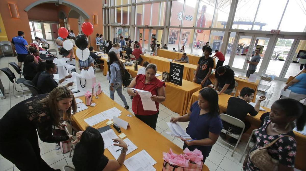 In this Tuesday, Oct. 6, 2015, photo, people attend a job fair at Dolphin Mall in Miami. The federal government issues its October jobs report Friday, Nov. 6, 2015.