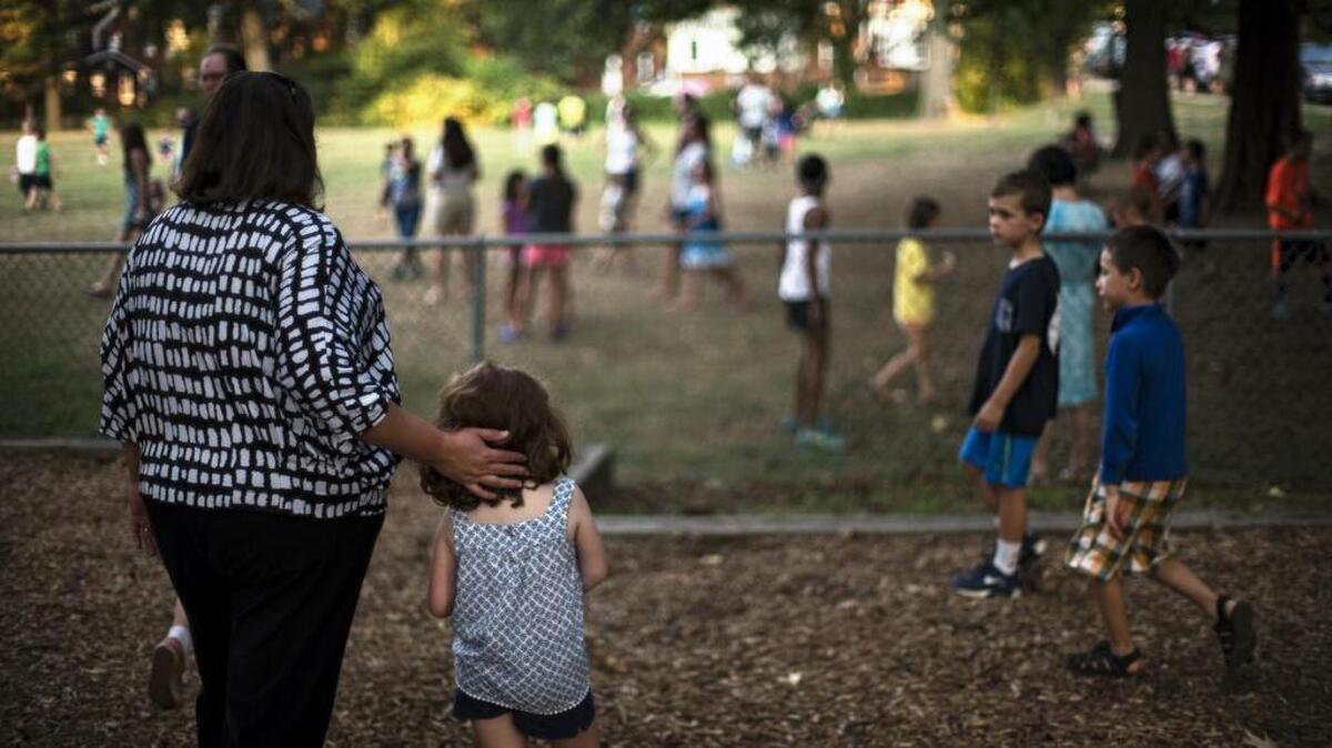 Kindergartner Isabella Bjornson and her mother, Jo Ann, attend a school ice-cream social at Madison Manor Park in Arlington, Va., on Sept. 9, 2016. Jo Ann Bjornson worries about starting her smart but sensitive 5-year-old daughter in kindergarten too early.
