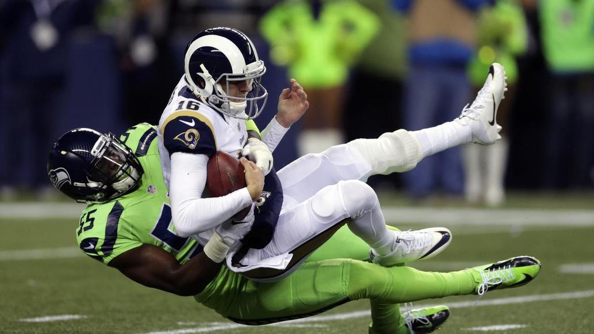 Los Angeles Rams quarterback Jared Goff, top, is sacked by Seattle Seahawks defensive end Frank Clark in the first half of an NFL football game, Thursday, Dec. 15, 2016, in Seattle.