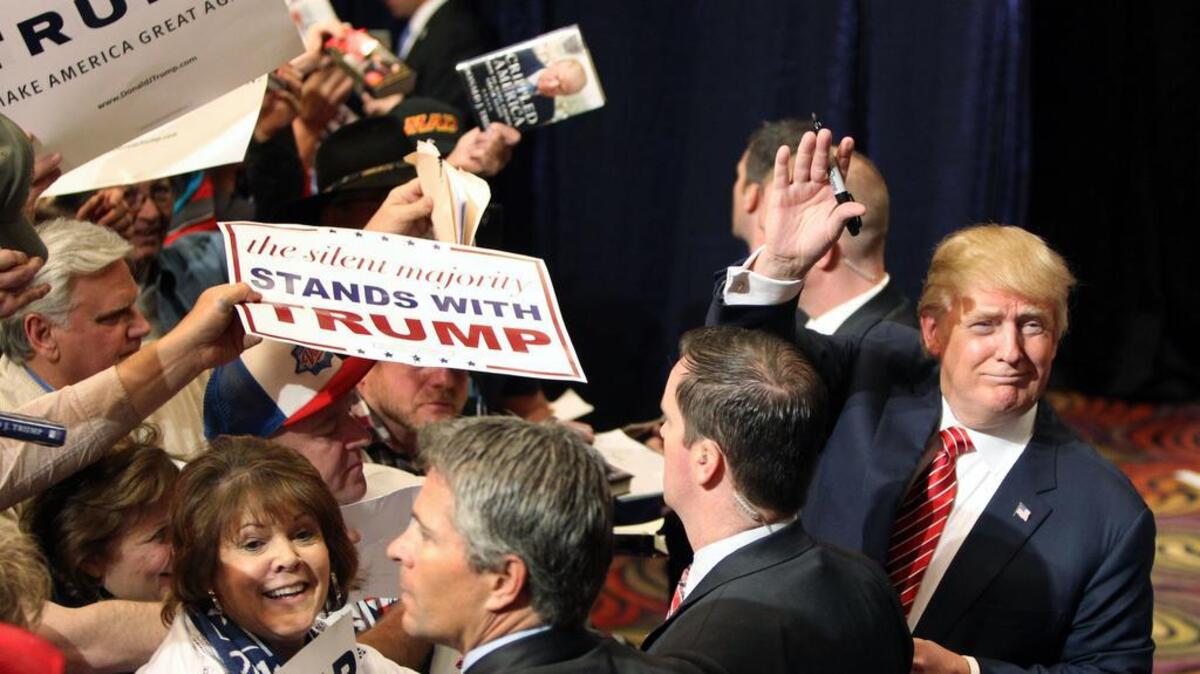 Republican presidential candidate Donald Trump, right, waves to a group of people greet after he spoke at a rally in Reno, Nev., on Sunday.