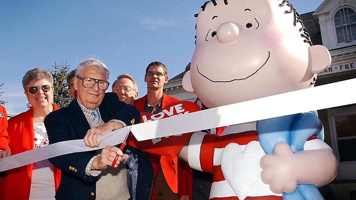 The real Linus, artist Linus Maurer, cuts a ribbon after unveiling a statue of Linus of "Peanuts" comic strip fame during a ceremony at his hometown of Sleepy Eye, Minn., on Sept. 23, 2003.
