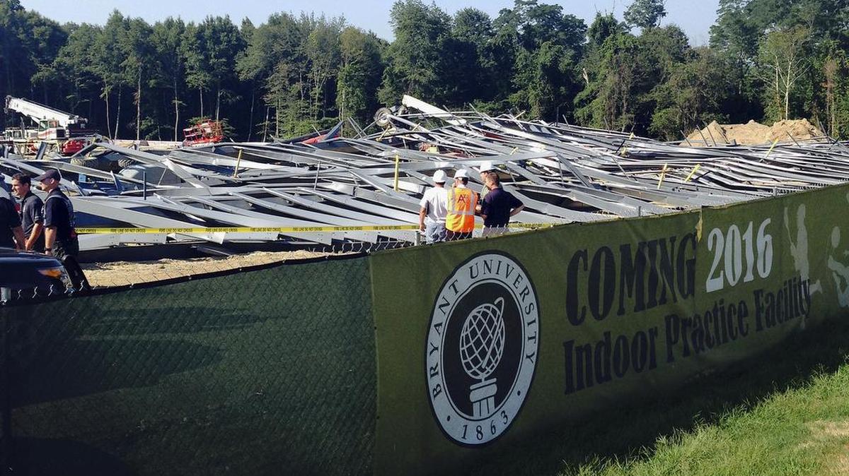 
People walk past bent steel at a construction site where an athletic practice facility on the Bryant University campus collapsed Tuesday, Sept. 1, 2015, in Smithfield, R.I. Workers were installing steel beams on a new indoor practice facility around 8:15 a.m. when the beams collapsed, university spokeswoman Elizabeth O’Neil said. 
