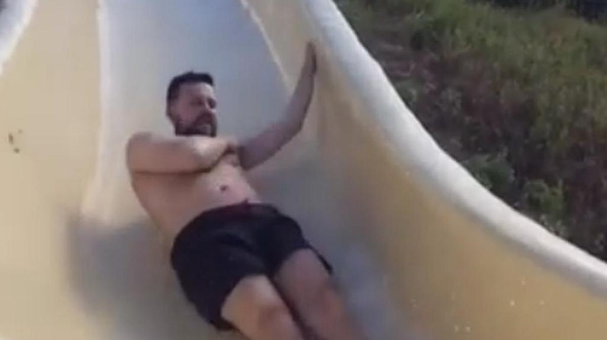 David Salmon slides down a water slide over rocky cliffs at Lake Travis in Austin.