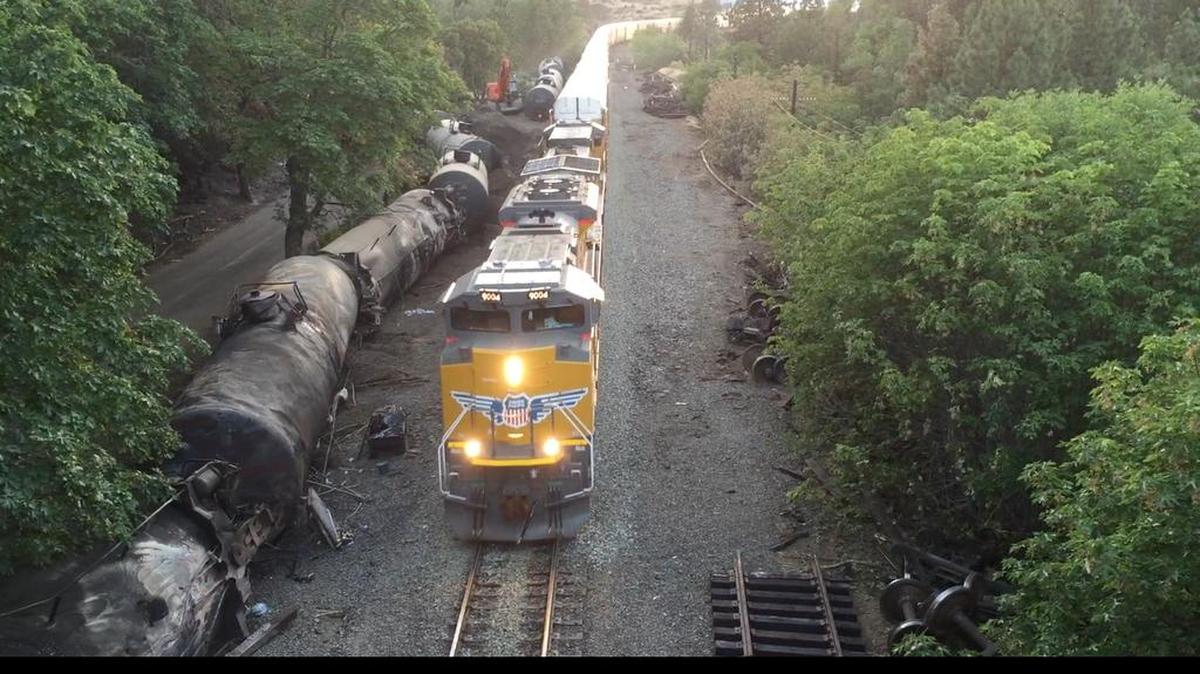 Crumpled oil tankers lie beside the railroad tracks after a fiery train derailment Friday that prompted evacuations from the tiny Columbia River Gorge town of Mosier, Ore., about 70 miles east of Portland. Trains began running Sunday and at least eight had moved through the town of about 400 people carrying mixed goods – but no crude oil – by Monday. Union Pacific defended its actions Monday, saying it was safe to run other trains by while crews continued to drain oil from the crashed tankers.