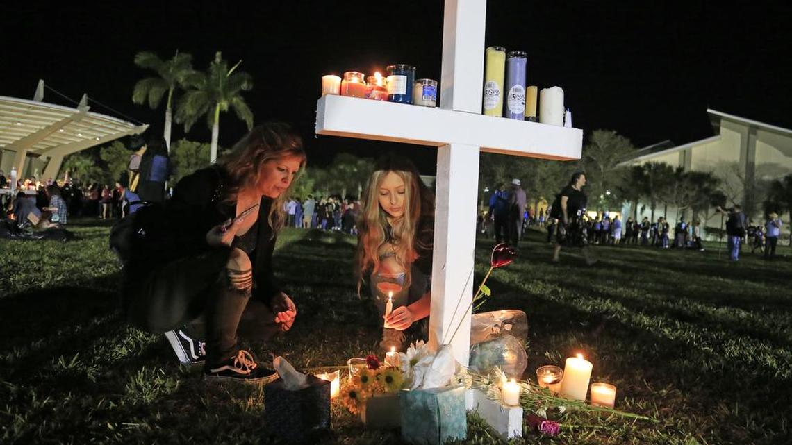 Attendees place candles on a cross at Pines Trails Park & Amphitheater after a vigil for the shooting victims at Marjory Stoneman Douglas High School.