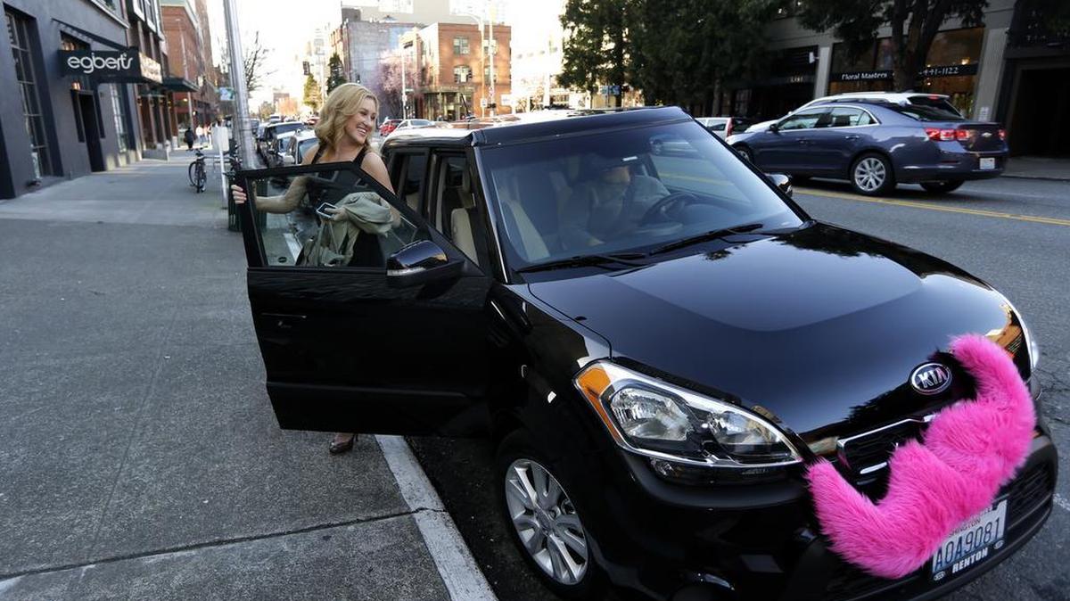 Katie Baranyuk gets out of a car driven by Dara Jenkins, a driver for the ride-sharing service Lyft, after getting a ride to downtown Seattle on March 12, 2014. Seattle became the first city to let drivers of ride-hailing companies such as Uber and Lyft collectively bargain over pay and working conditions.