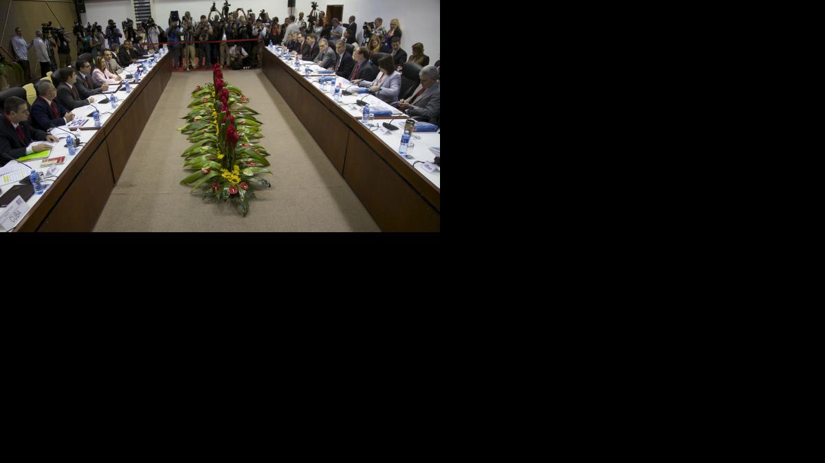 
Members of a U.S. delegation, right, and Cuban delegates, left, sit across from each other as they begin negotiations, in Havana, Cuba, Wednesday, Jan. 21, 2015. The highest-level U.S. delegation to Cuba in decades kicked off two days of negotiations Wednesday after grand promises by President Barack Obama about change on the island and a somber warning from Cuba to abandon hopes of reforming the communist government. 

