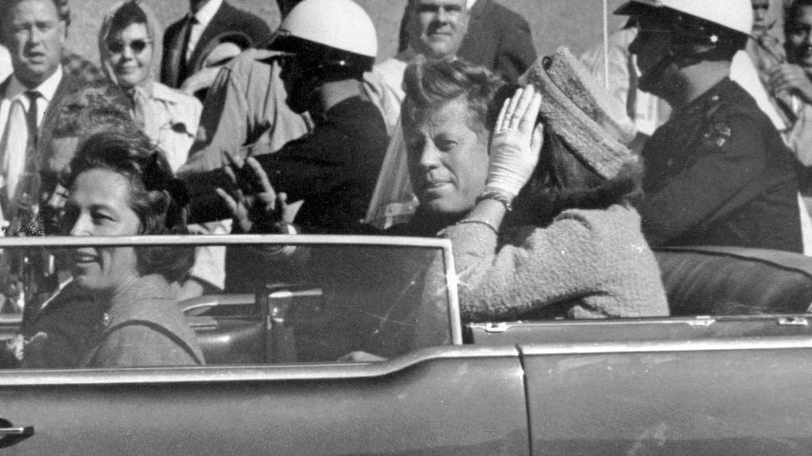FILE - In this Nov. 22, 1963 file photo, President John F. Kennedy waves from his car in a motorcade in Dallas. Riding with Kennedy are First Lady Jacqueline Kennedy, right, Nellie Connally, second from left, and her husband, Texas Gov. John Connally, far left.