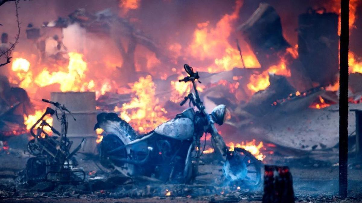 A motorcycle burns near a structure during the Clayton Fire in Lower Lake on Sunday, Aug. 14, 2016.