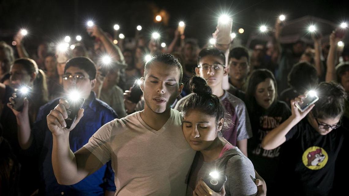 Matthew Mata and Erika Gonzalez participate in a memorial service for the victims of Sunday's church shooting in Sutherland Springs, Texas, on Monday, Nov. 6, 2017. The suspected gunman had a history of domestic violence and sent threatening text messages to his mother-in-law, a member of the church, before the attack in which he fired at least 450 rounds at helpless worshippers, authorities said Monday.