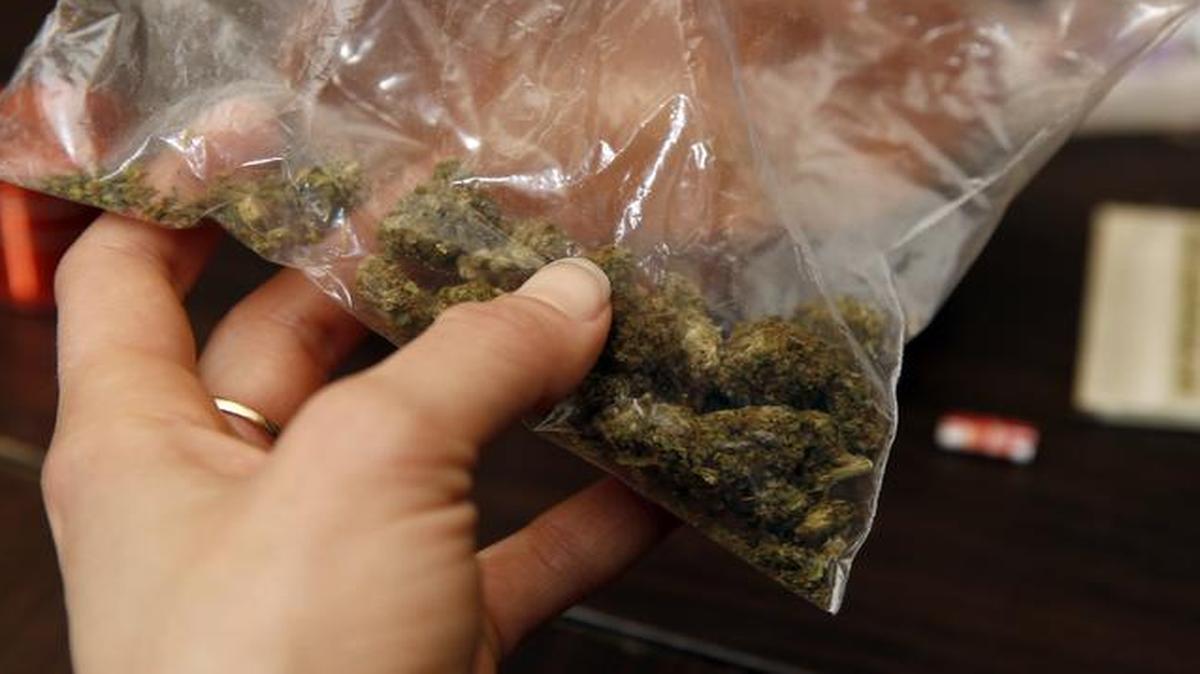 
Rica Madrid poses for a photograph as she holds a bag of pot as she prepares to roll a joint in her home on the first day of legal possession Thursday, Feb. 26, 2015, in Washington, D.C., which joined Alaska, Colorado and Washington state in legalizing the possession of marijuana for recreational use. 
