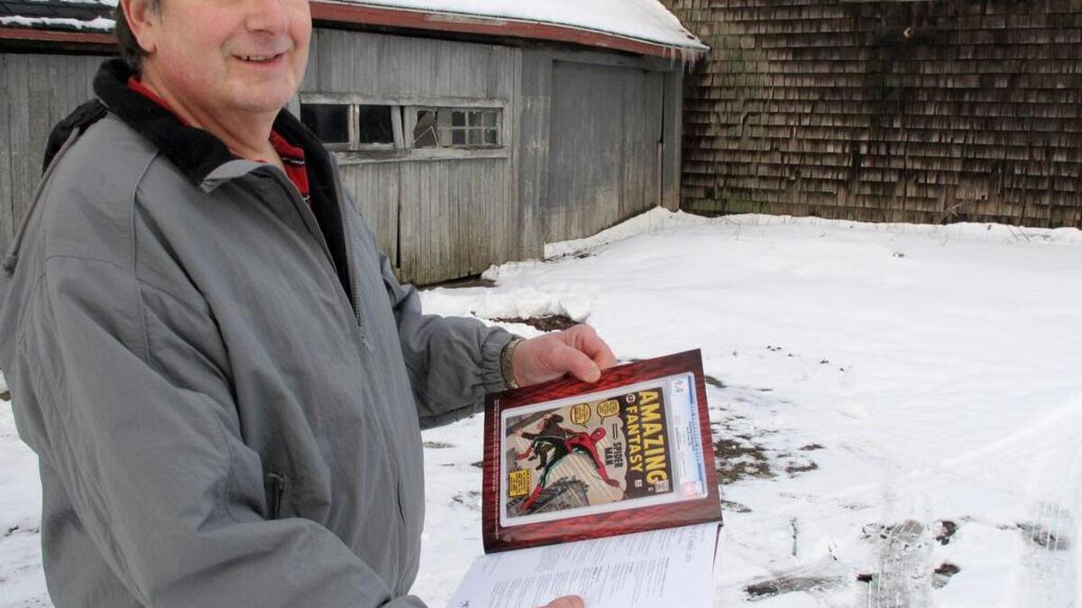 In this photo taken Tuesday, Feb. 9, 2016, in Calverton, N.Y., Walter Yakoboski holds an auction guide featuring one of his comic books, “Amazing Fantasy” No. 15, which features the Spider-Man character. Yakoboski bought the comic book as an investment in 1980 for $1,200. Some experts believe it could fetch $400,000 or more when it is sold at auction on Feb. 18.