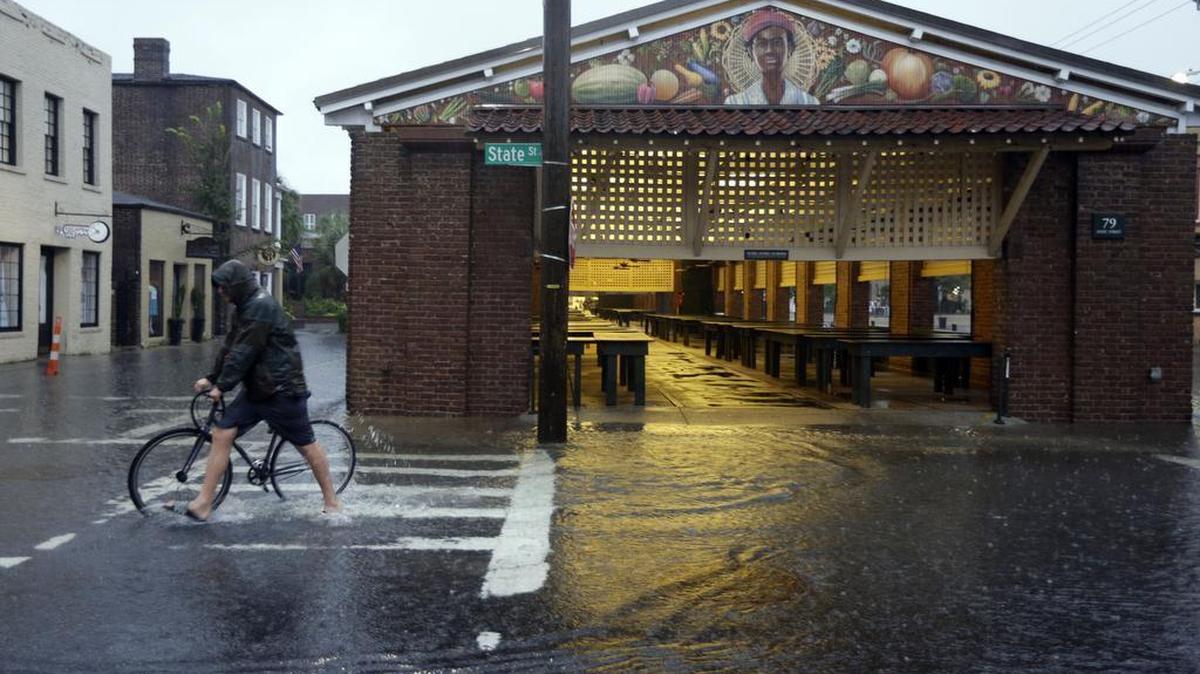 
A man walks his bicycle through high water at the City Market in downtown Charleston, S.C., Saturday, Oct. 3, 2015. The National Weather Service says the risk of flooding will continue through Monday morning, especially in parts of North and South Carolina that already have gotten up to 11 inches of rain this week. Forecasters say some areas could see storm totals as high as 15 inches. 
