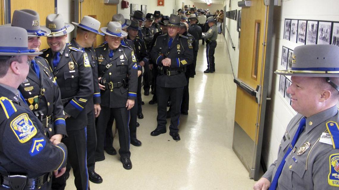 State and local police officers line up outside an auditorium prior to an awards ceremony on Dec. 12, 2013, at the Connecticut State Police Training Academy in Meriden, Conn. Some police departments are relaxing age-old standards for accepting recruits.