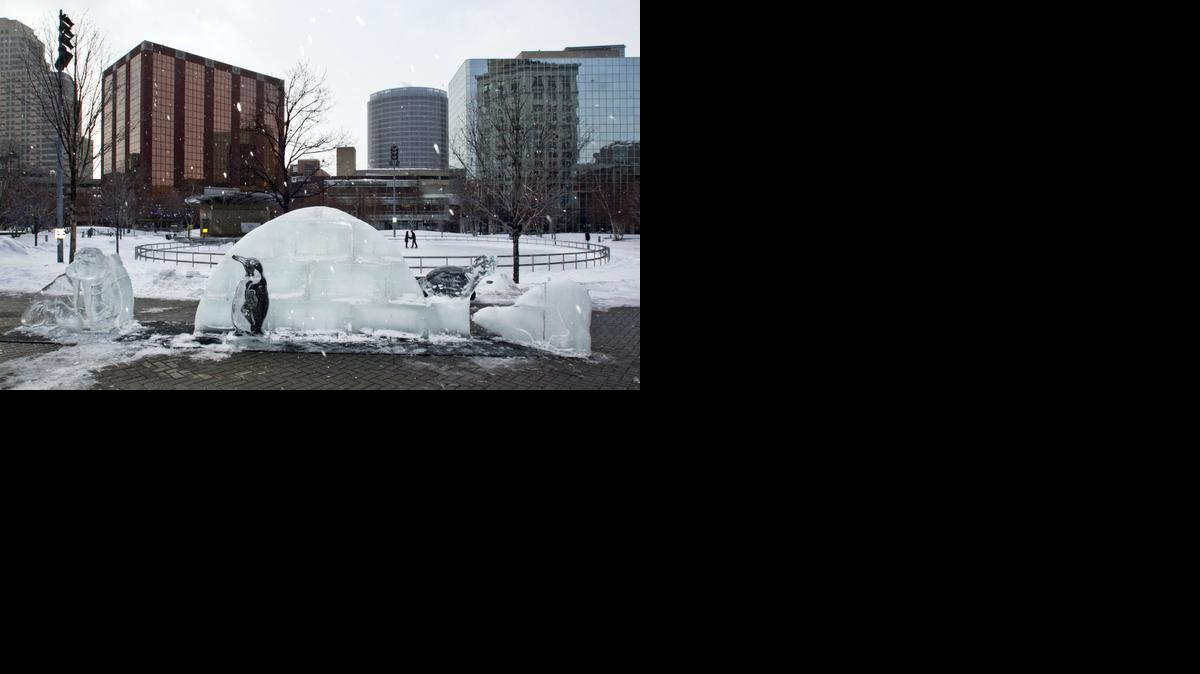 
People stake by ice sculptures of an igloo and arctic animals made by Ice Sculptures Ltd., at Rosa Parks Circle, in Grand Rapids, Mich., Saturday, Feb. 14, 2015. 
