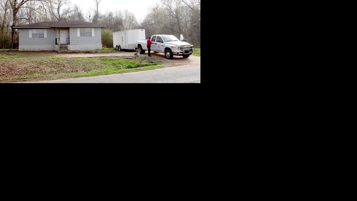 Los funcionarios del condado Claiborne se preparan para salir de una casa en Port Gibson, Mississippi, donde las autoridades estaban investigando el ahorcamiento de un hombre negro en los bosques vecinos, jueves, 19 de marzo de 2015. El hombre no ha sido identificado.