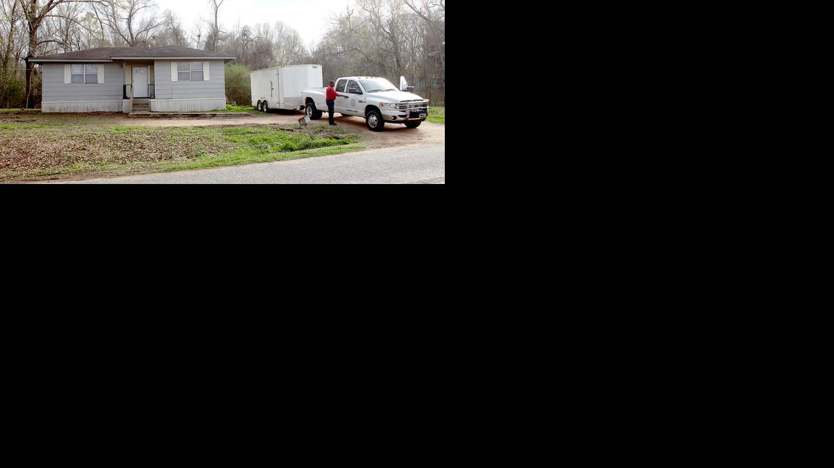 Los funcionarios del condado Claiborne se preparan para salir de una casa en Port Gibson, Mississippi, donde las autoridades estaban investigando el ahorcamiento de un hombre negro en los bosques vecinos, jueves, 19 de marzo de 2015. El hombre no ha sido identificado.
