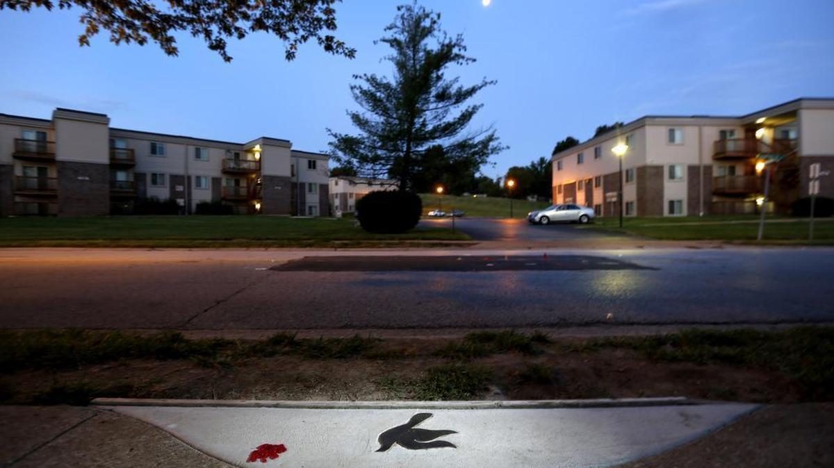 
In this Sunday, Aug. 2, 2015, photo, a marker in the shape of a dove is embedded in the sidewalk near the spot where Michael Brown was shot and killed by police officer Darren Wilson in Ferguson, Mo. A year ago, Ferguson was thrust into the national spotlight after the death of Brown giving way to the "Black Lives Matter" movement. 
