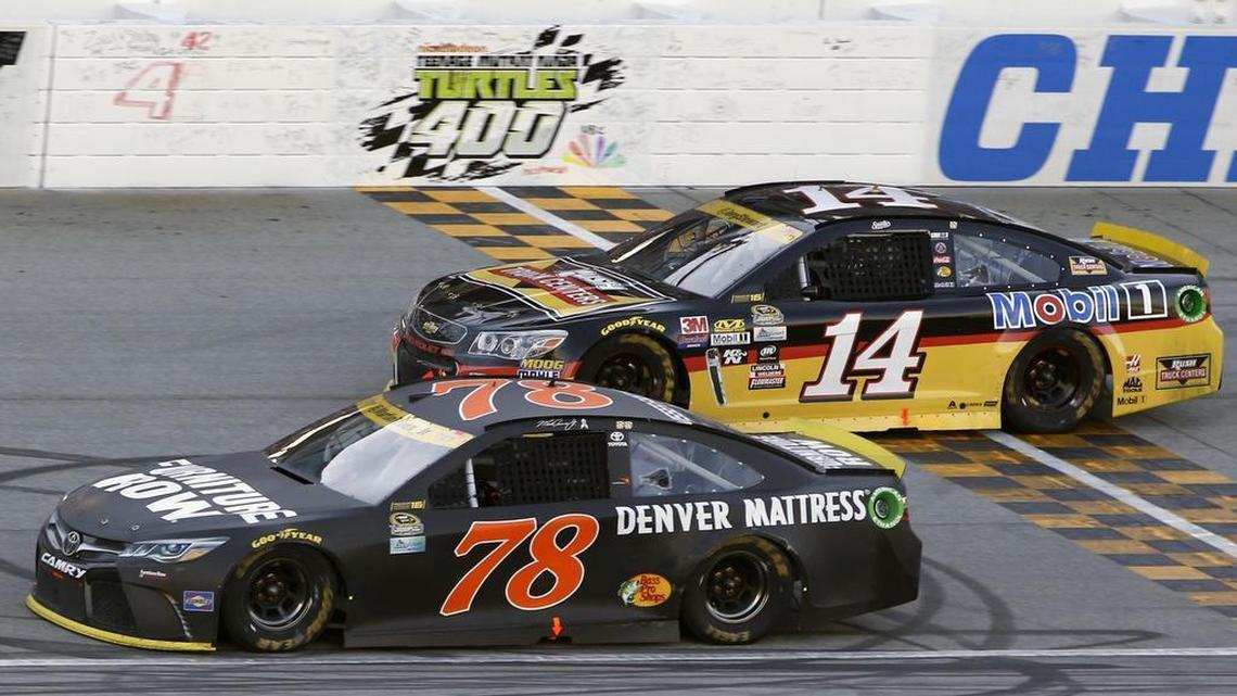 Martin Truex Jr. (78) drives past Tony Stewart (14) during a NASCAR Sprint Cup Series auto race at Chicagoland Speedway on Sunday.