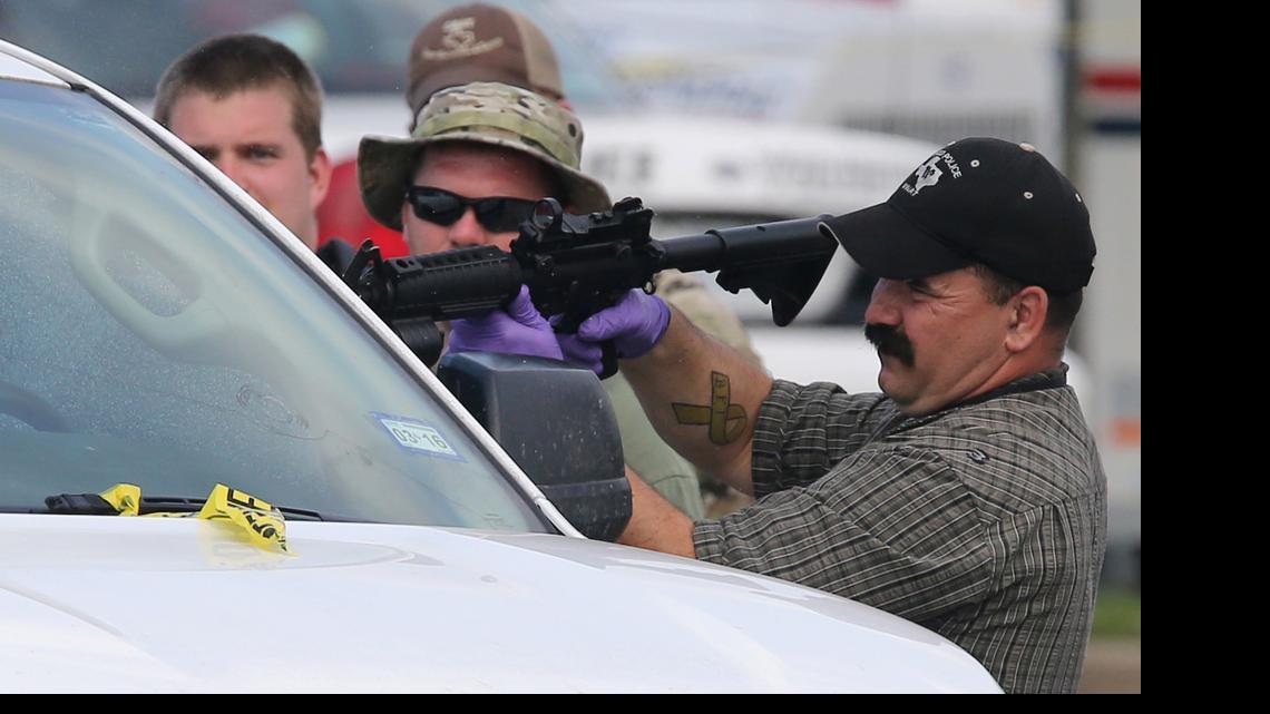 
A law enforcement officer uses a rifle to break the window of a vehicle in the parking lot of a Twin Peaks restaurant May, 19, 2015, in Waco, Texas. A deadly weekend shootout involving rival motorcycle gangs at the restaurant apparently began with a parking dispute and someone running over a gang member's foot, police said Tuesday.

