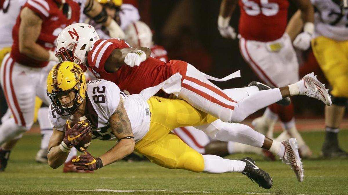 FILE - In this Nov. 12, 2016, file photo, Minnesota wide receiver Drew Wolitarsky (82) makes a catch while being defended by Nebraska safety Kieron Williams, top, during the second half of an NCAA college football game in Lincoln, Neb. the Gophers have a new sunny bowl venue by the sea to explore in San Diego. They will play in the Holiday Bowl in San Diego against Washington State on Dec. 27.