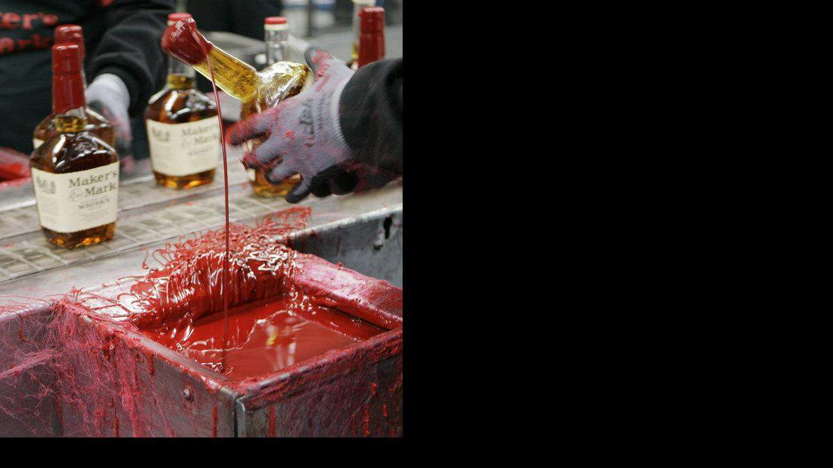 
A bottle of Maker's Mark bourbon is dipped in red wax during a tour of the distillery in Loretto, Ky., on April 8, 2009. 
