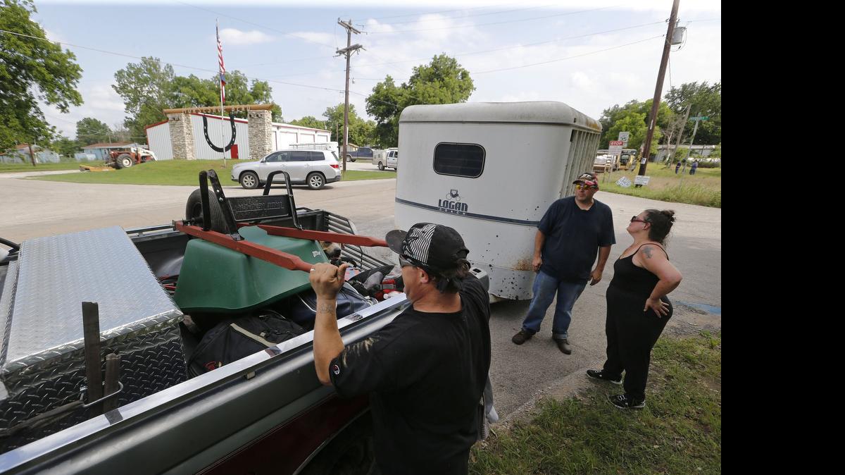 
Rhett Pfaffenhauser loads his belongings onto Cheyenne Cobb's truck as he and his friend Deborah Arlin, right, leave Horseshoe Bend, Texas, for safer shelter Wednesday as authorities called for an evacuation of the community with the Brazos River expected to flood.
