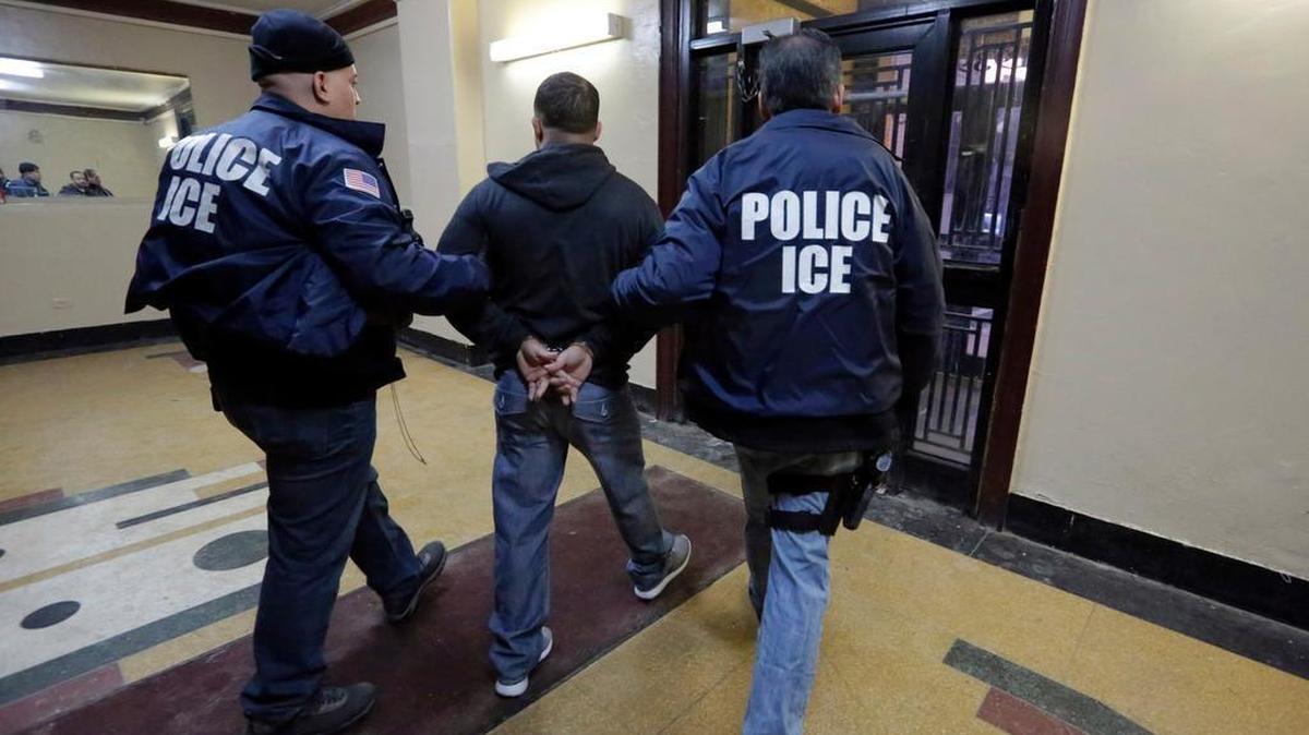 The nation’s highest immigration court has blocked the deportations of a handful of families who were apprehended as part of an effort to combat illegal immigration. In this March 3, 2015 photo, Immigration and Customs Enforcement officers escort a detainee in an apartment building in the Bronx borough of New York during a series of early-morning raids.