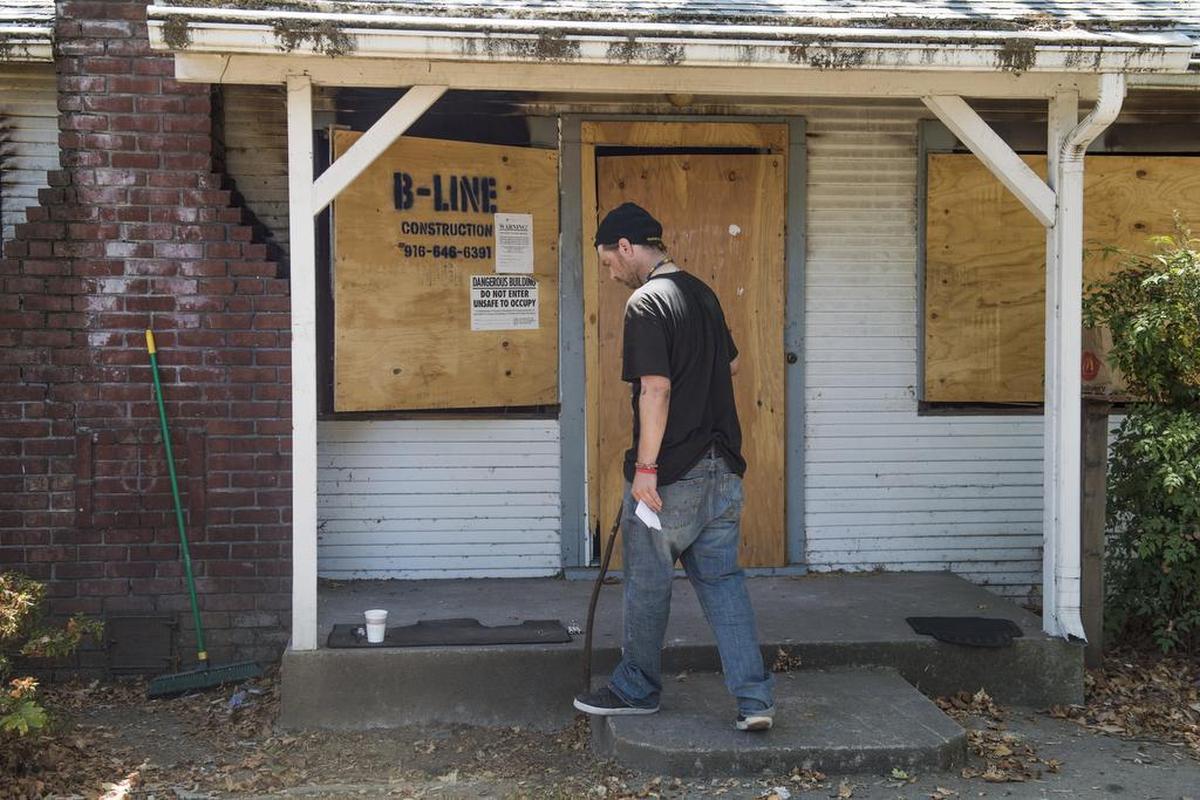 Thomas Mullen walks to the front porch of the abandoned home he has been staying in on Truckee Way off 34th Street on Wednesday July 19, 2017, in Sacramento, Calif. Mullen has been staying there since July 12, when Caltrans impounded his "pod" home. Thomas' father, Jim, built the pod for his son.