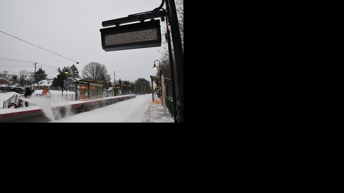 
As Long Island Railroad workers clear snow from the platform of the Glen Head station on Tuesday, Jan. 27, 2015, in Glen Head, N.Y., an announcement sign informs travelers of the suspension of service that started at 11 p.m. Monday evening due to a blizzard that hit the New York area overnight.
