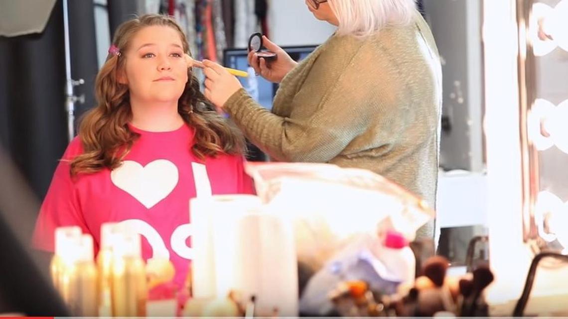 Wichitan Lexi Harris sits during a makeup session for a PromGirl commercial in this screenshot from the company’s video.