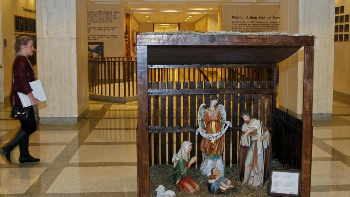 A woman walks by the Christmas Nativity scene installed at the Florida Capitol in Tallahassee, Dec. 3, 2013. To promote peace and avoid dissension, the group that organized the display will not do a Nativity scene this year.