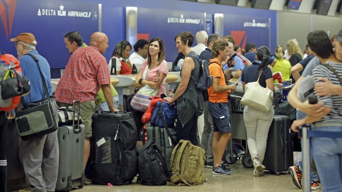 Passengers stand in line after Delta Air Lines flights resumed Monday, Aug. 8, 2016, in Salt Lake City, following a computer outage. Delta Air Lines delayed or canceled hundreds of flights Monday after its computer systems crashed, stranding thousands of people on a busy travel day.