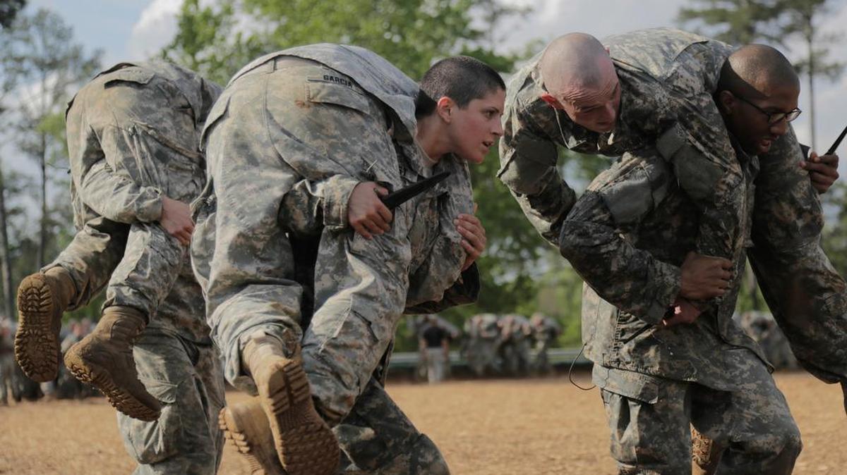 
Capt. Kristen Griest, center, one of two women becoming the first female soldiers to graduate from Army Ranger School, carries another soldier while holding a knife. 
