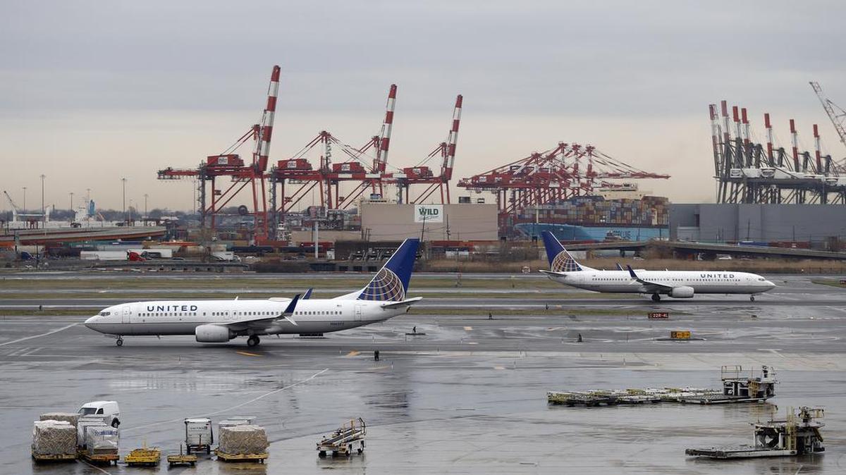 Cranes from the Port of Newark give backdrop to United Airlines planes taxing at Newark Liberty International Airport, Wednesday, April 12, 2017, in Newark, N.J.