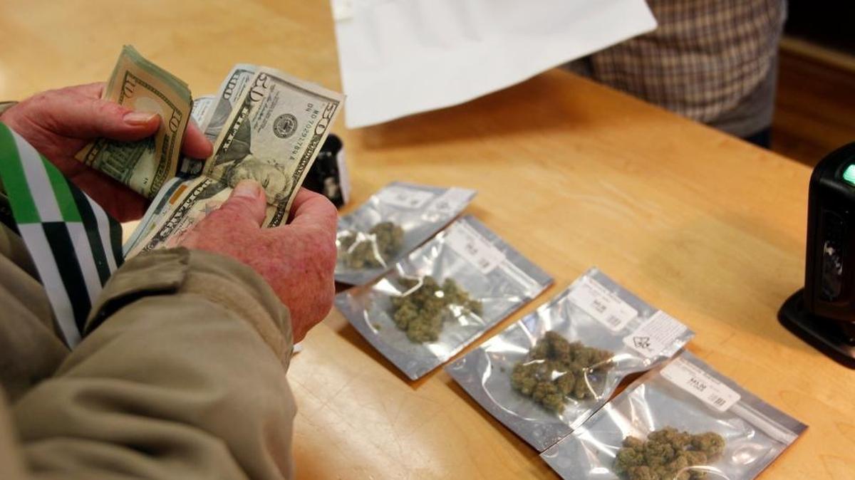 A customer purchases marijuana at Harborside marijuana dispensary on Monday in Oakland, Calif. On New Year’s Day recreational marijuana could be sold legally in California, but an announcement by Attorney General Jeff Sessions could disrupt the market.