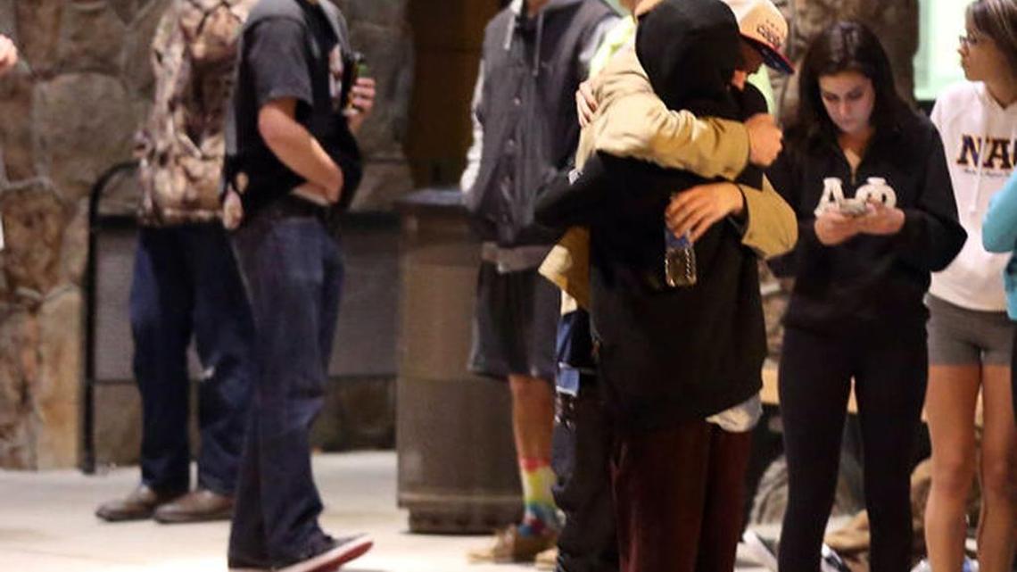 
Students embrace outside a hospital emergency room in Flagstaff, Ariz., on Friday, Oct. 9, 2015, after an early morning fight between two groups of college students escalated into gunfire, leaving one person dead and three others wounded, authorities said. The shooting occurred outside a dormitory near the Northern Arizona University campus.
