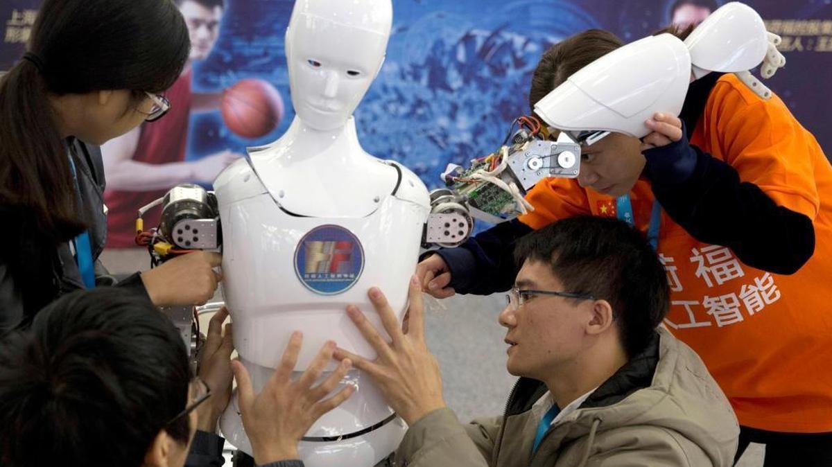 Chinese students work on the Ares, a humanoid bipedal robot designed by them with funding from a Shanghai investment company, displayed during the World Robot Conference in Beijing on Oct. 21, 2016. China's goal is to transform the country into a global leader in artificial intelligence in just over a decade.