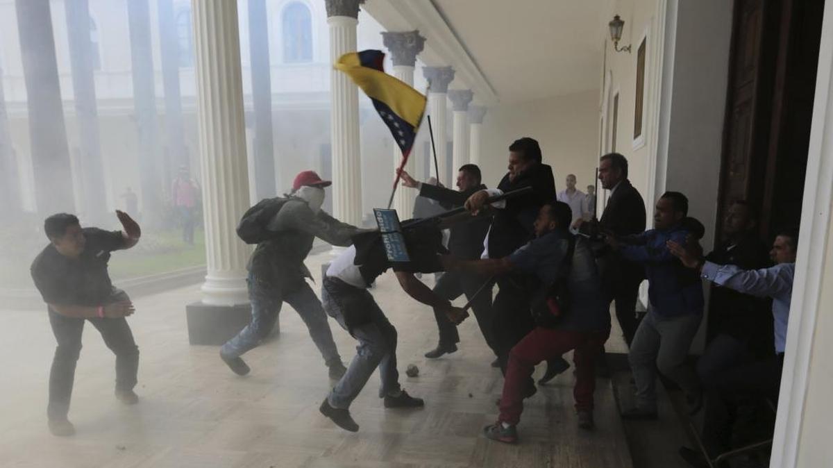 Opposition lawmakers brawl with pro-government militias who are trying to force their way into the National Assembly during a special session coinciding with Venezuela's independence day, in Caracas, on July 5, 2017. At least five lawmakers were injured in the attack. (AP Photos/Fernando Llano)