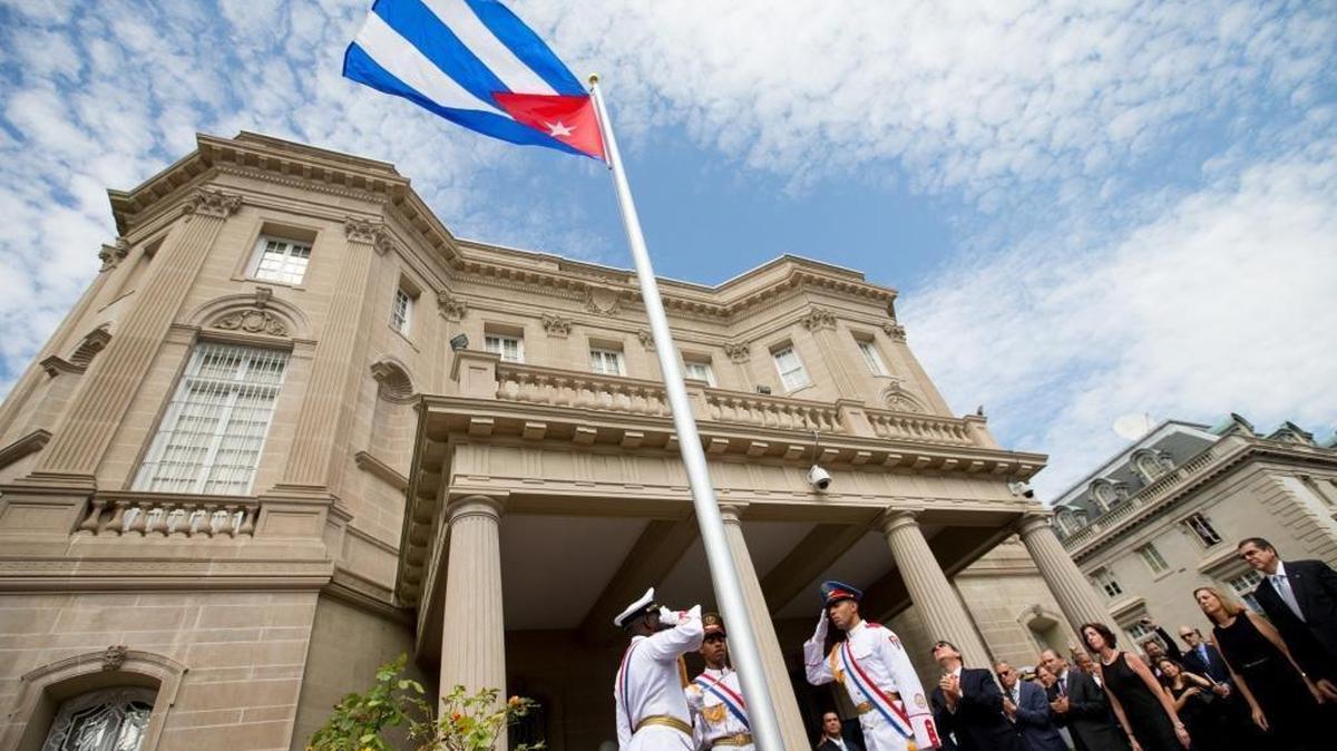 Cuban Foreign Minister Bruno Rodriguez, right of center, applauds with other dignitaries after raising the Cuban flag over their new embassy in Washington, Monday, July 20, 2015.