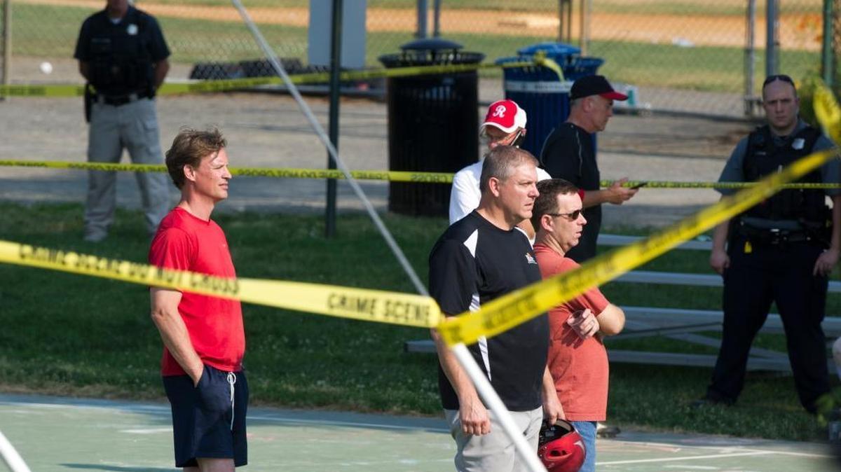 Members of the Republican Congressional baseball team stand behind police tape in Alexandria, Va., Wednesday, June 14, 2017, after a multiple shooting involving House Majority Whip Steve Scalise of Louisiana during a congressional baseball practice.