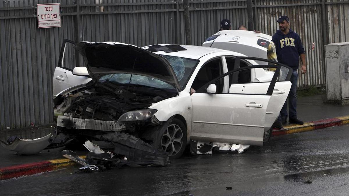 Israeli police examine a car used in a vehicular attack Monday in Jerusalem. A Palestinian rammed his car into a bus station wounding nine people before he was shot and killed by bystanders, police said.