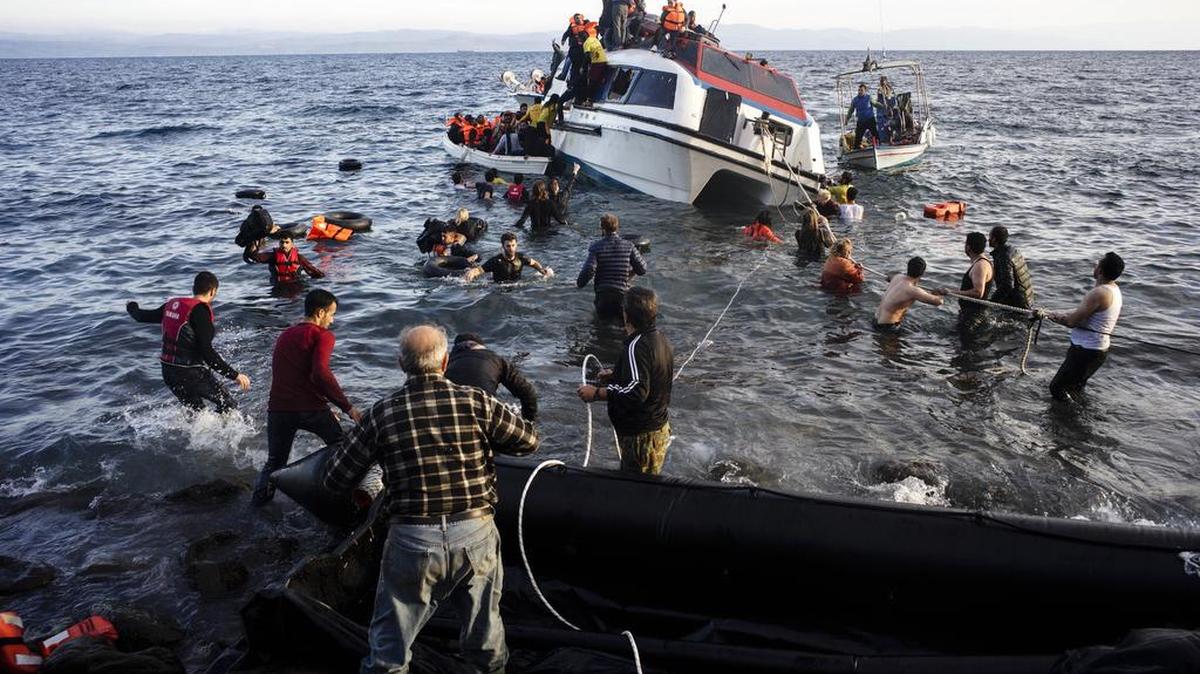 Volunteers and local residents help refugees and migrants disembark from a small vessel after their arrival in Skala Sykaminias on the northeastern Greek island of Lesbos on Friday, Oct. 30, 2015. Greek authorities say a number of people have died near other islands after two boats carrying migrants and refugees from Turkey to Greece sank overnight, in the latest deadly incident in the eastern Aegean Sea.