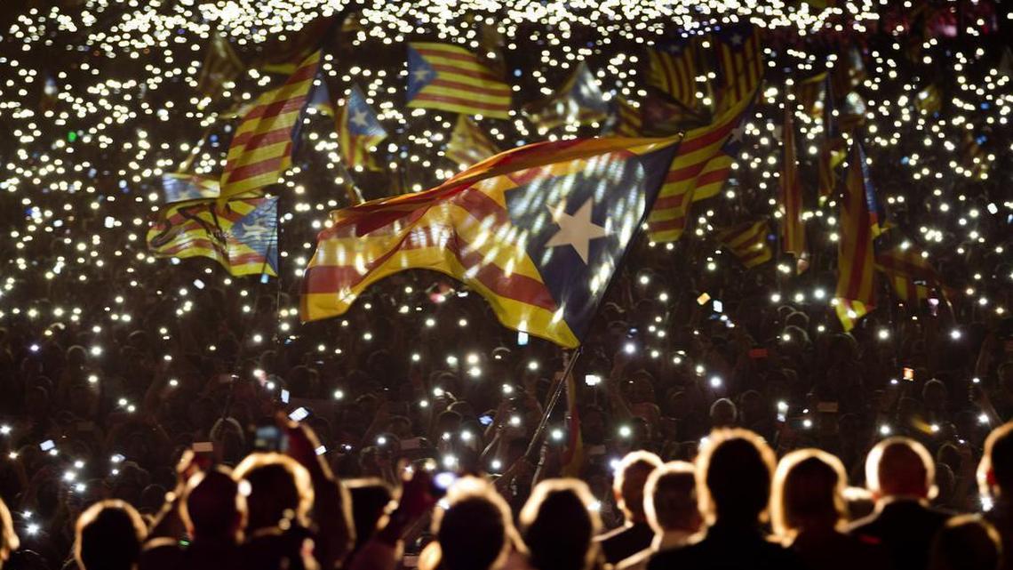 In this Friday, Sept. 25, 2015 file photo, pro independence supporters wave "estelada" or pro independence flags during a rally of "Junts pel Si" or "Together for YES" in Barcelona, Spain. The region’s president declared independence from Spain this week, and the Spanish prime minister is threatening to remove Catalonia’s autonomy if they don’t drop the bid within eight days.