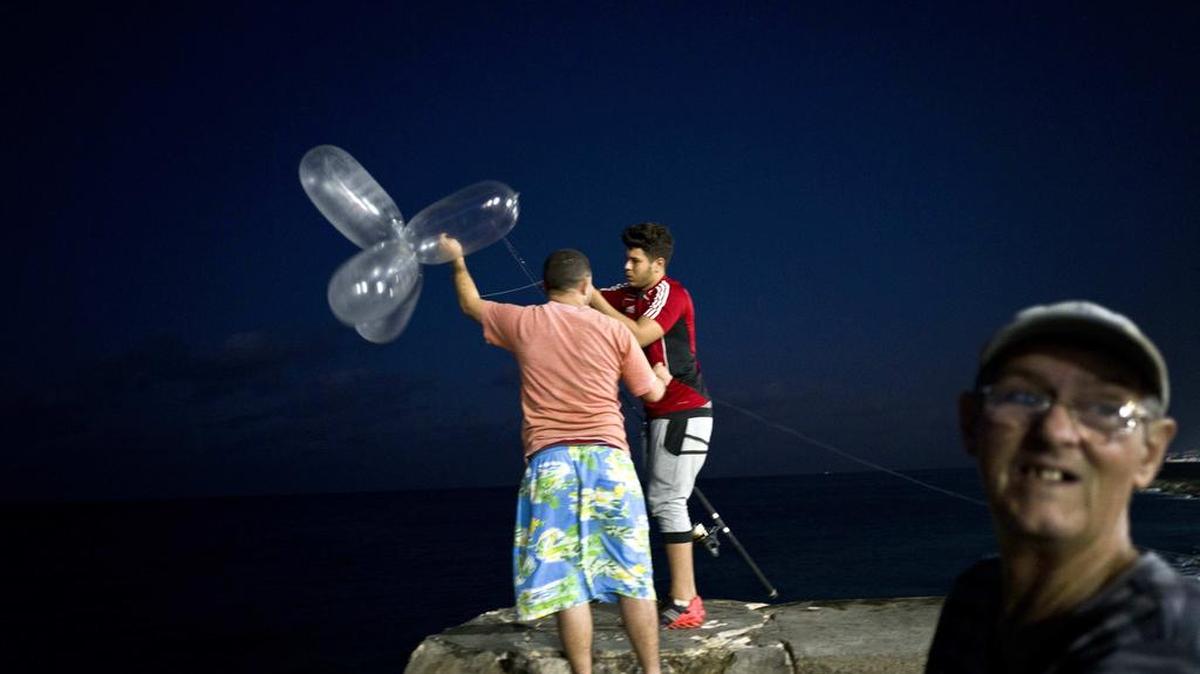 Derek Aguiar Gonzalez prepares to cast his line, which is fitted with inflated condoms that serve to keep the bait high in the water and increase his casting distance, at the malecon seawall in Havana, Cuba.