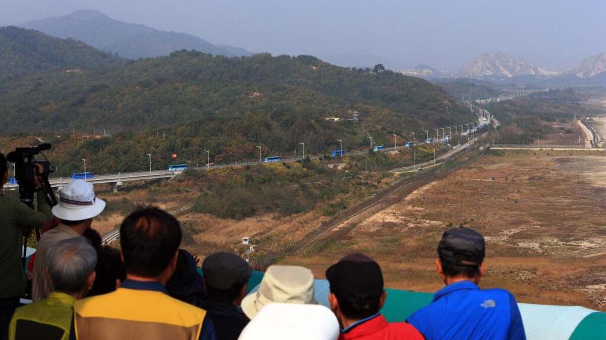 
Tourists watch buses carrying South Koreans cross the border to Diamond Mountain resort in North Korea, at the Unification Observation post in Goseong, South Korea, Tuesday, Oct. 20, 2015. 
