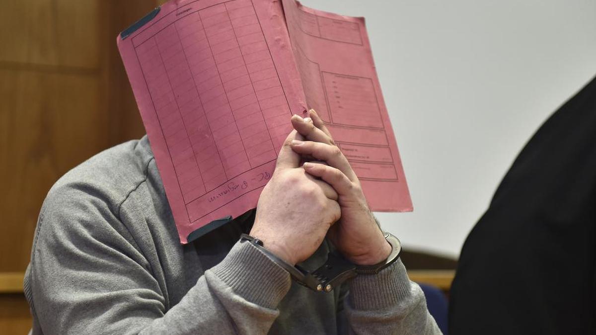 In this Feb. 26, 2015, photo, former nurse Niels Hoegel, covers his face with a file at the district court in Oldenburg, Germany. German authorities say Monday Aug. 28, 2017, they now believe that Hoegel, who was convicted of killing two patients with overdoses of heart medication, killed at least 84 people. Hoegel was convicted in 2015 of two murders and two attempted murders at a clinic in the northwestern town of Delmenhorst.