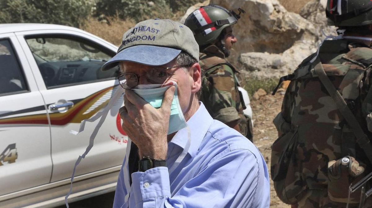
In this June 20, 2011, photo taken during a government-organized tour for foreign diplomats and the media, U.S. ambassador to Syria Robert Ford covers his nose during his visit with other foreign diplomats to a mass grave in Jisr el-Shughour in northern Syria.
