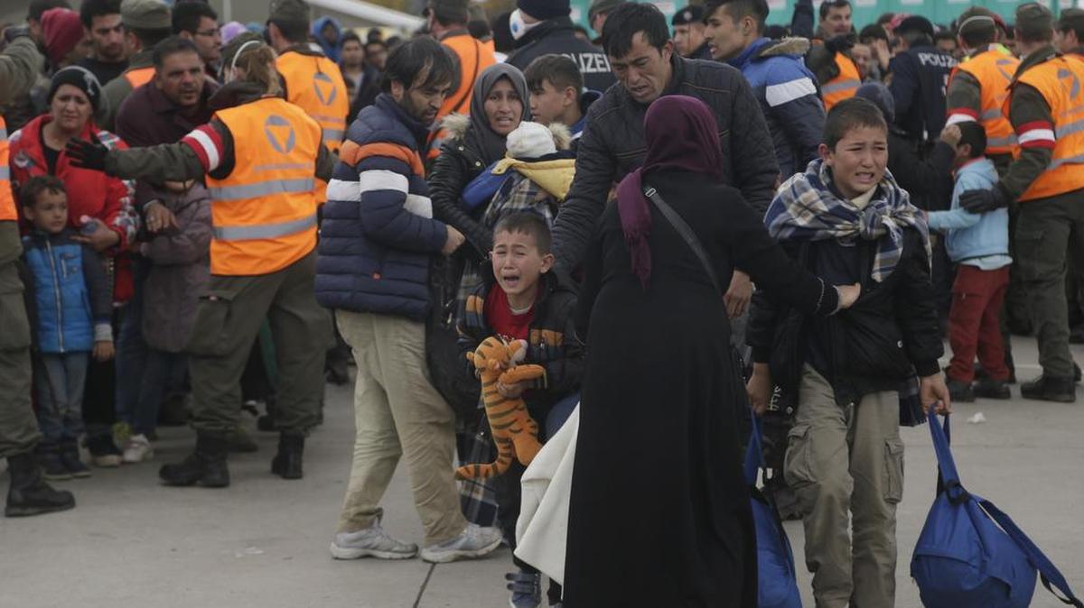 A family walks toward buses at a camp at a border with Slovenia in Spielfeld, Austria, Thursday, Oct. 22, 2015. Thousands of people are trying to reach central and northern Europe via the Balkans but often have to wait for days in mud and rain at the Serbian, Croatian and Slovenian borders.